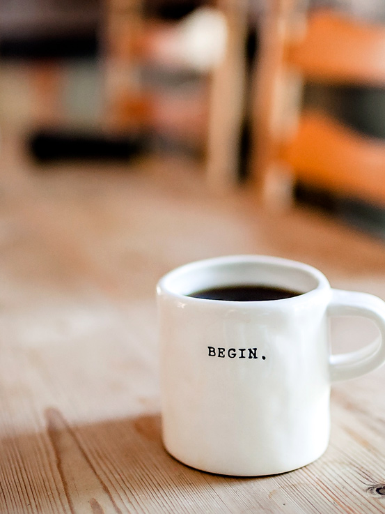 Taza de café con la leyenda “begin”